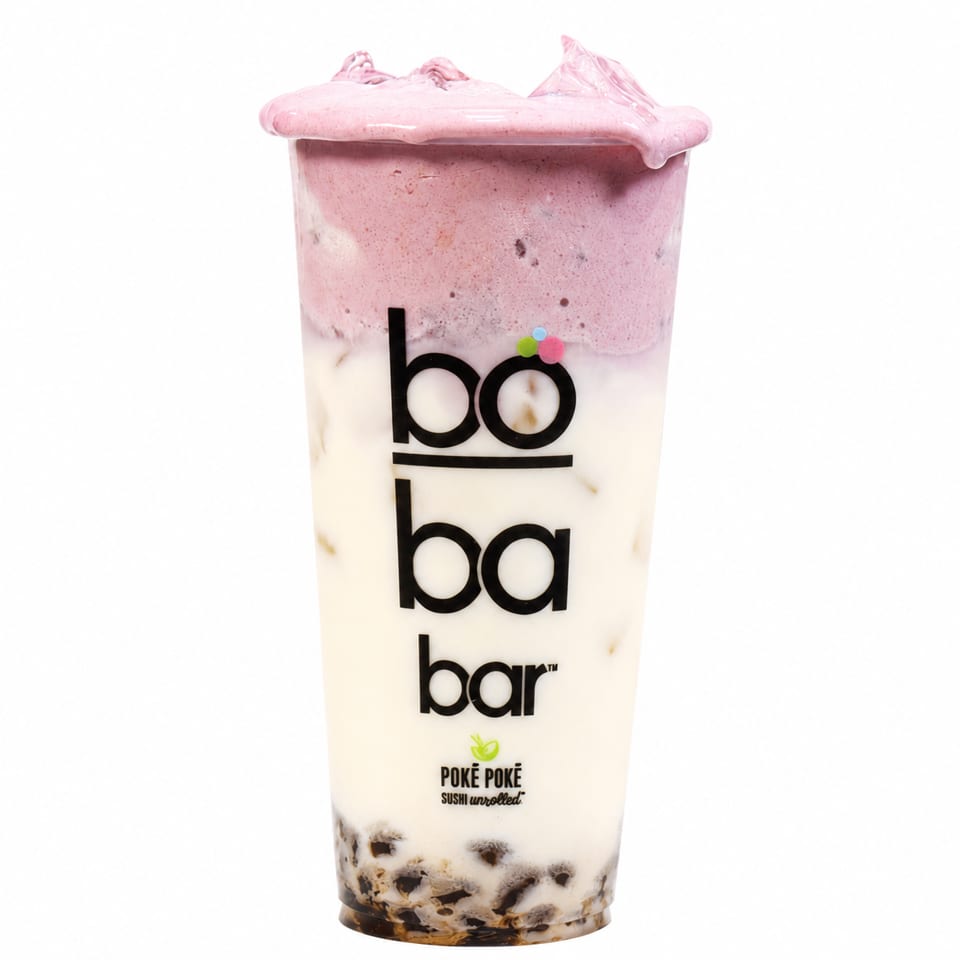 Boba Bar drink with layers of dark boba, white milk, and pink foam on top.